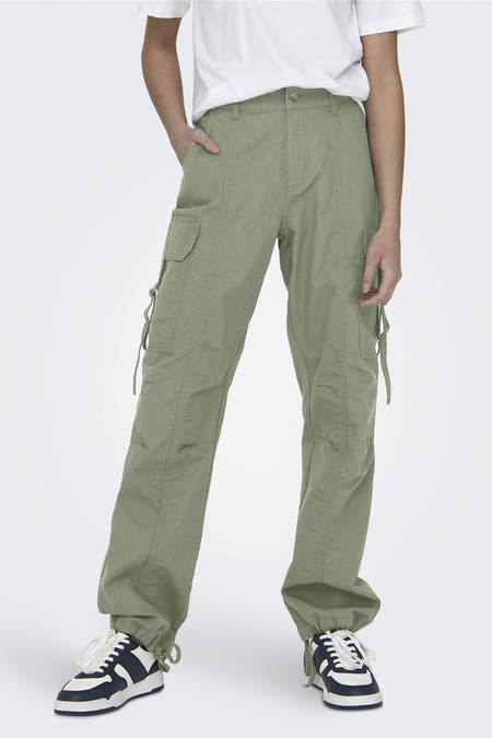 Groene cargobroek van ONLY, met zakken en details bij de pijpen, gecombineerd met een wit t-shirt en sneakers.
