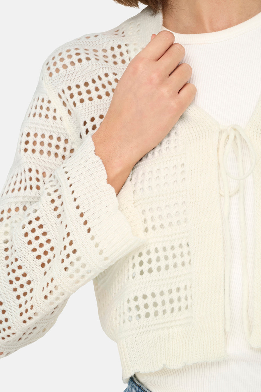 Gebroken wit, gebreid vest met open details.