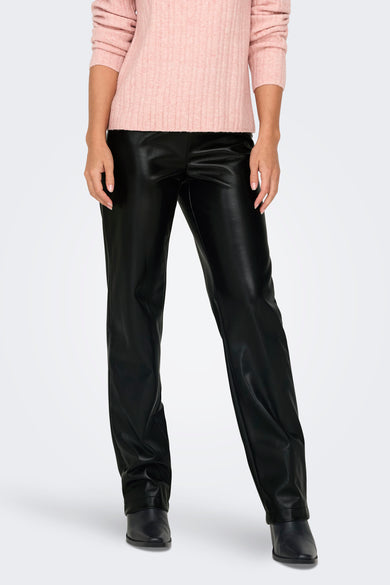 Pantalon noir de ONLY, avec un aspect cuir et porté avec une chemise rose.