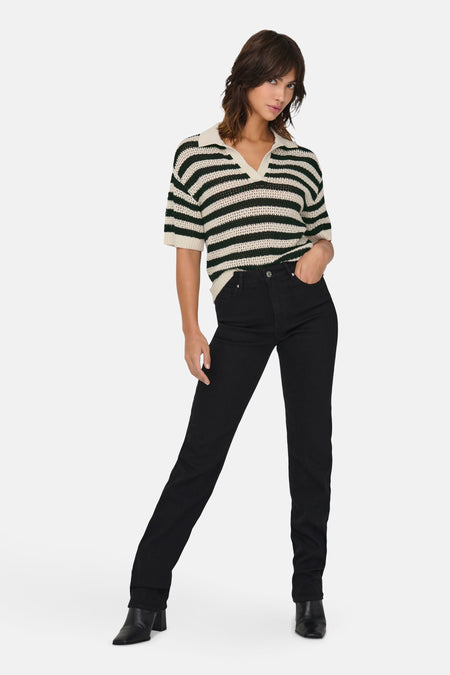 Polo multicolore à manches courtes de JDY, avec un motif rayé et porté avec des jeans noirs et des bottes.