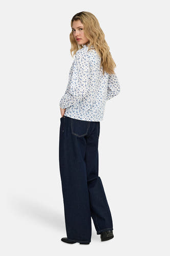 Chemisier blanc à manches longues de ONLY®, avec un motif floral bleu, porté avec un jean ample.