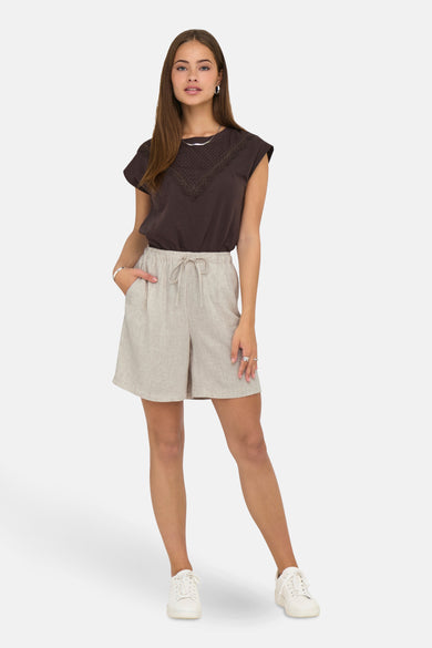 Ecru short van ONLY, met trekkoord en zakken, gecombineerd met een bruine top en witte sneakers.
