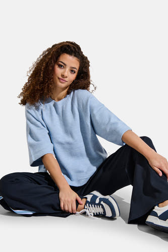 T-shirt bleu avec col rond de ONLY, porté par un modèle ajusté avec des pantalons foncés et des baskets.