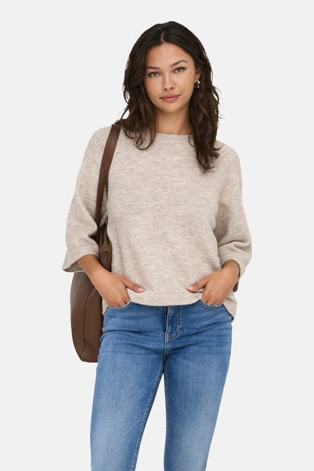 Beige trui met ronde hals van ONLY, gecombineerd met blauwe jeans en een bruine leren tas.
