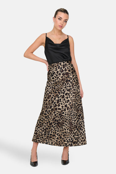 Lange bruine rok van ONLY, met luipaardprint en gecombineerd met een zwarte top en pumps.
