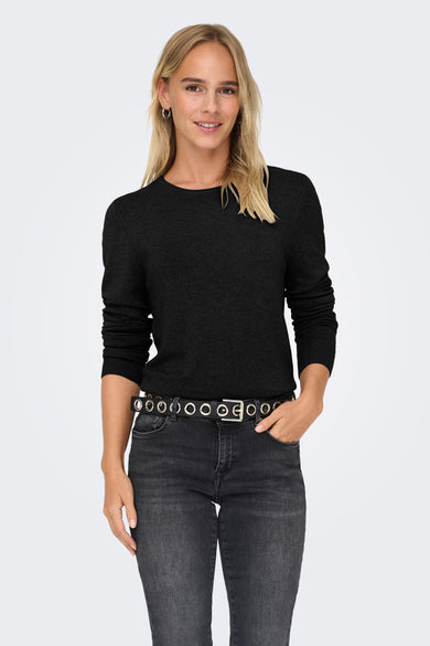 Beige pull met ronde hals van ONLY, gedragen met een zwarte riem met oogjes en een grijze jeans.
