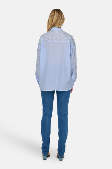 Blauw gestreept hemd met lange mouwen van ONLY, met zilveren details, gecombineerd met een donkerblauwe jeans.
