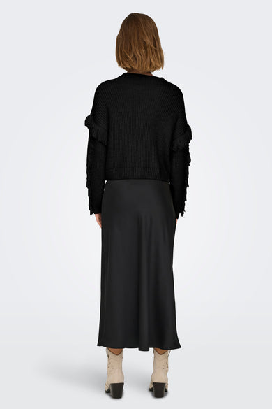 Pull-over noir à col rond de ONLY, avec des détails froncés, associé à une jupe noire et des sandales beige.