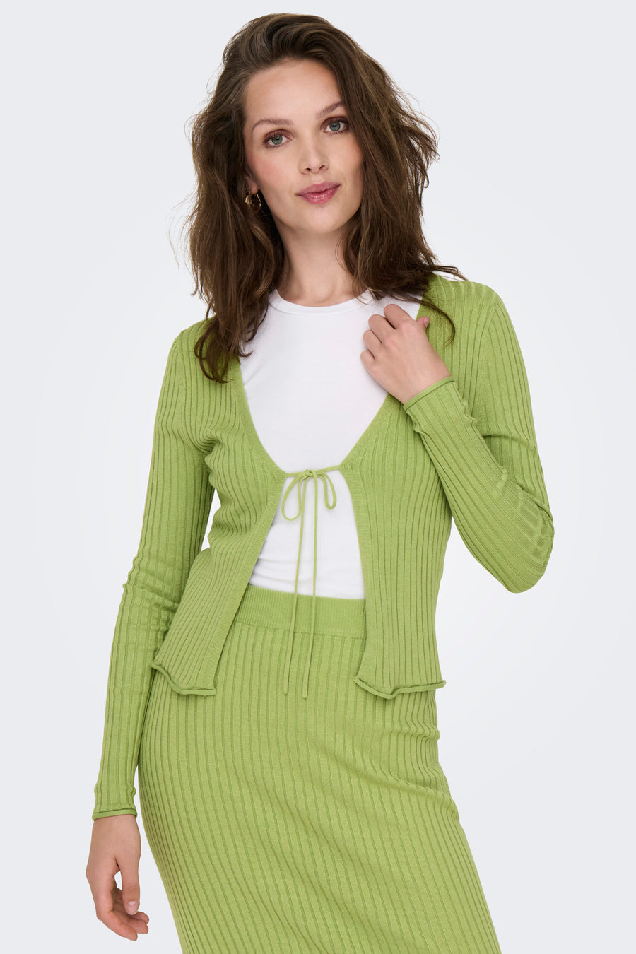 Gilet vert de ONLY, combiné avec un shirt blanc et une jupe verte à rayures.