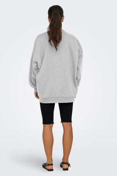 Grijze sweater van ONLY, gedragen met zwarte fietsbroek en sandalen, achterkant.

