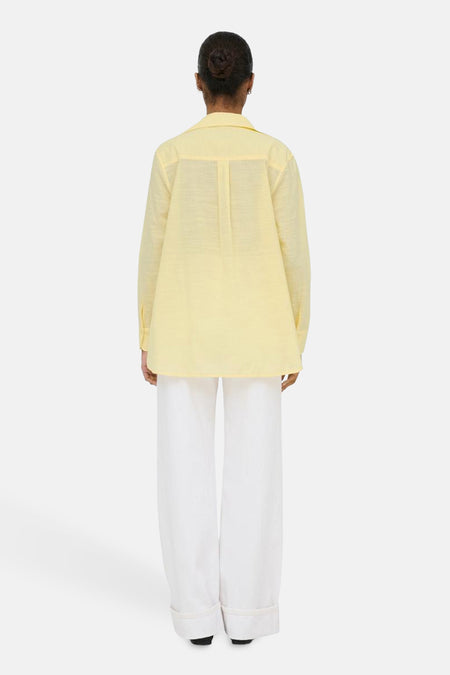 Geel hemd met lange mouwen van ONLY, gezien van achteren, gecombineerd met een witte broek.