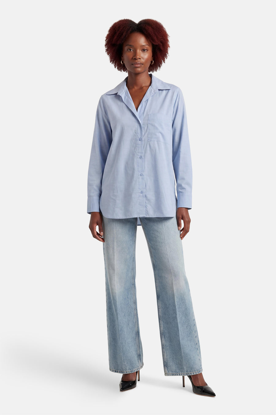 Blauw overhemd met lange mouwen van ONLY, met knoopsluiting en een borstzak, gecombineerd met wijde jeans en zwarte pumps.
