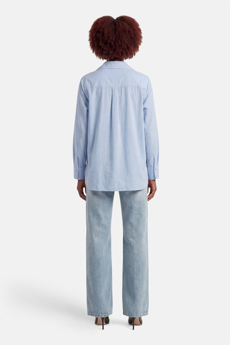 Blauw hemd met lange mouwen van ONLY, gezien van achteren, gedragen met wijde jeans en hakken.
