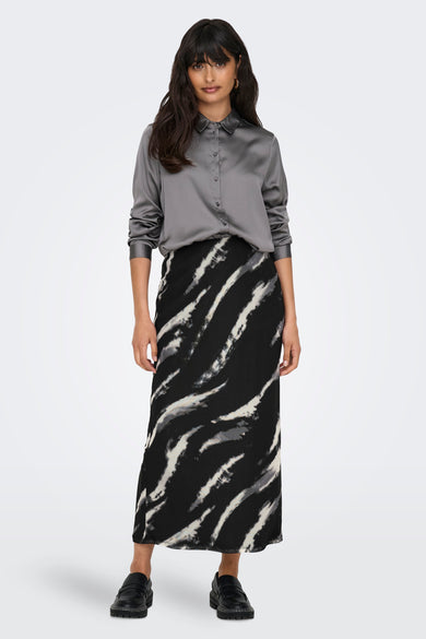 Grijze rok van ONLY, met een zwart-wit gestreept patroon, gecombineerd met een grijze satijnen blouse en zwarte schoenen.

