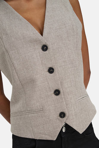 Beige blazer van ONLY, met vier zwarte knopen en een kleine zak, gecombineerd met een zwarte broek.