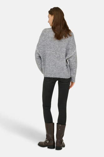 Sweat-shirt gris à col rond de JDY, avec des broderies décoratives sur les manches, associé à des jeans noirs et des bottes marrons.