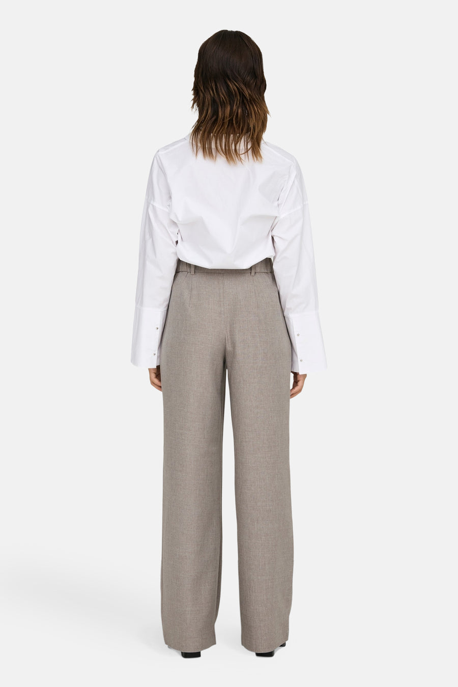 Beige kostuumbroek van ONLY, met wijde pijpen en een nette uitstraling, gecombineerd met een wit overhemd.
