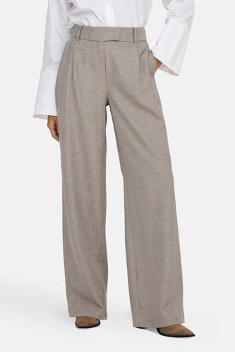 Pantalon de costume beige, d'ONLY®, avec des poches larges et une texture subtile, associé à un chemisier blanc.