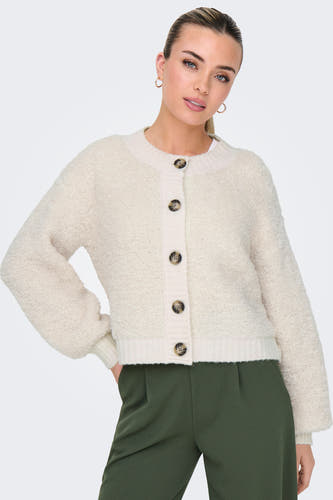 Cardigan écru de JDY, avec fermeture à boutons et longues manches, associé à un pantalon vert.