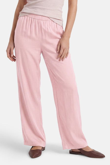Roze broek van ONLY® met elastische tailleband en wijde pijpen, gestyled met een licht topje en bruine platte schoenen.