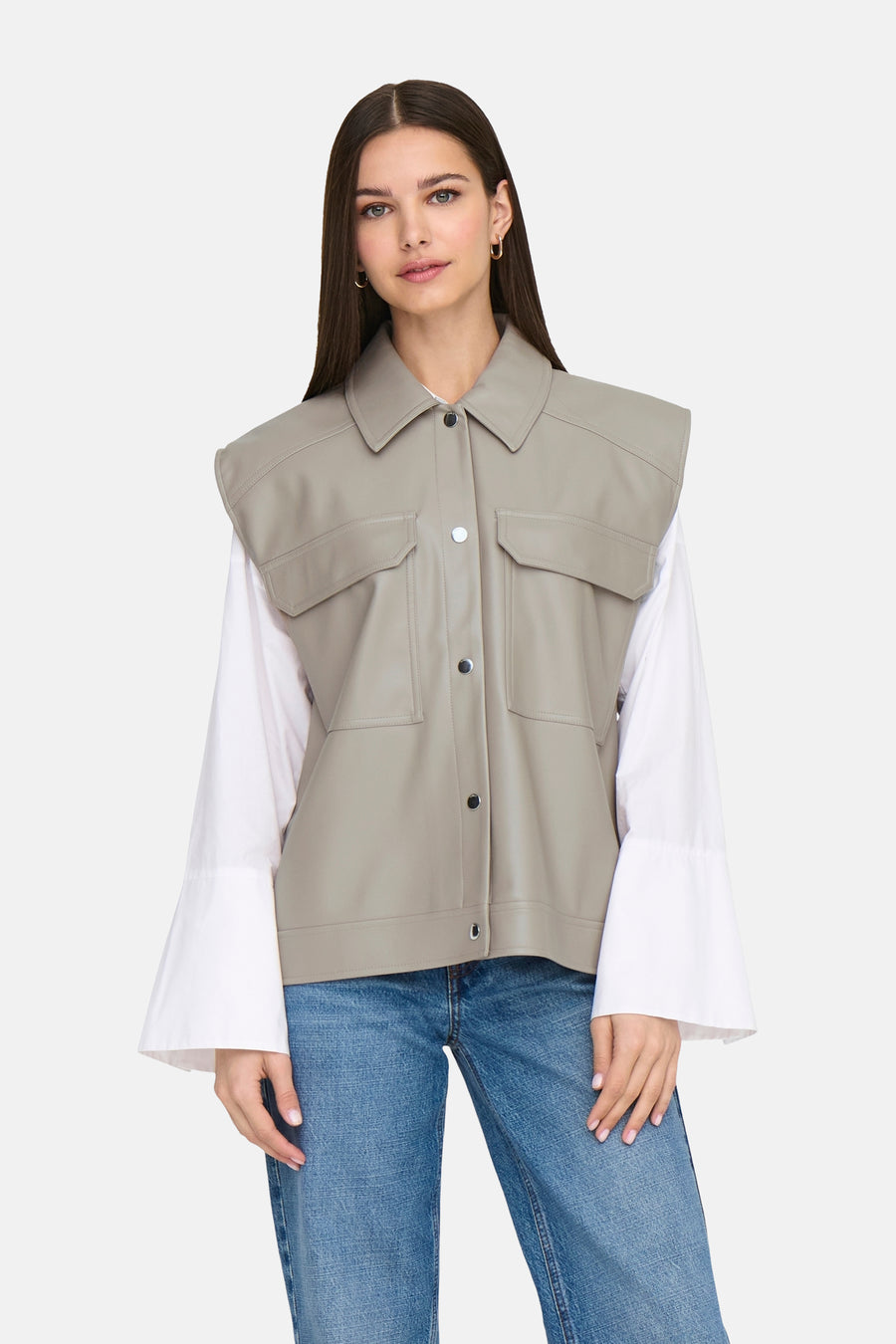 Beige leren jas van ONLY, met knoopsluiting en opgestikte zakken, gedragen over een wit overhemd en blauwe jeans.