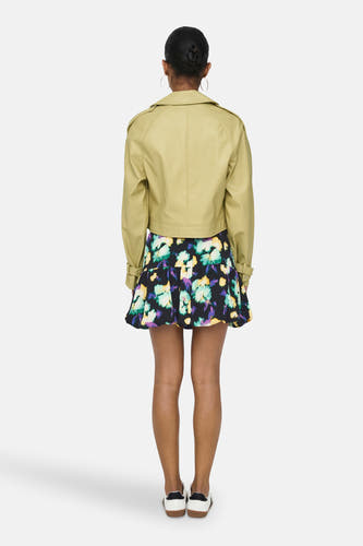 Gele leren jas van ONLY, met een krokodillenprint en gedragen met een bloemenrok.
