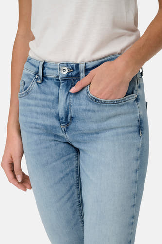 Lichtblauwe skinny jeans denim van ONLY, met een hand in de zak en een lichte top.
