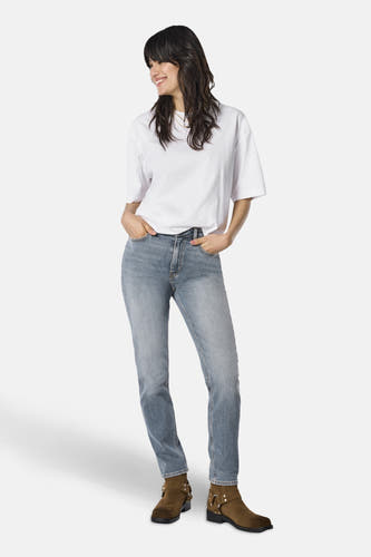 Mom jeans van middenblauw denim van ONLY, gedragen met een wit T-shirt en bruine laarzen.
