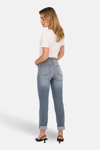 Mid blue denim mom jeans van ONLY, met opgerolde pijpen en gecombineerd met een wit t-shirt en zwarte hakken.
