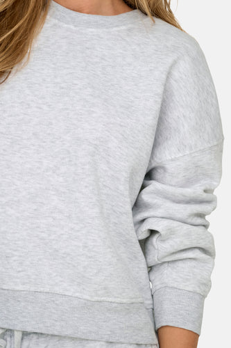 Grijze sweater met lange mouwen.
