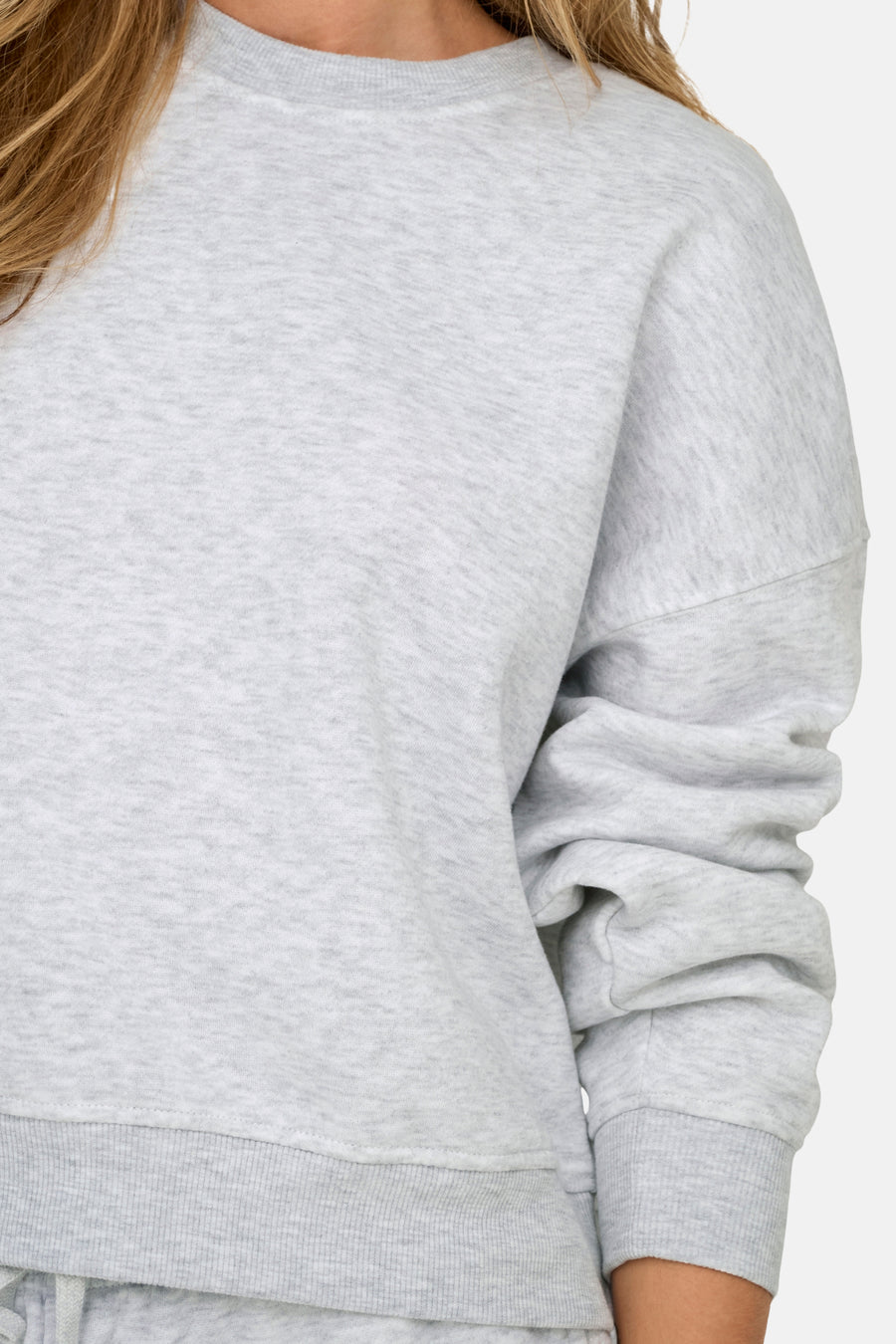 Grijze sweater met lange mouwen.
