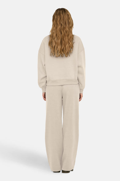 Gilet écru de ONLY, avec des manches longues et un col rond, vu de derrière.