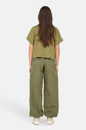 T-shirt kaki à manches courtes de ONLY, avec des manches retroussées et associé à un pantalon vert.