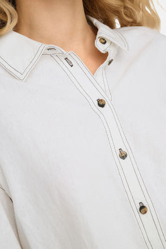 Chemise blanche à manches longues de ONLY, avec des boutons bruns et des ourlets sombres.