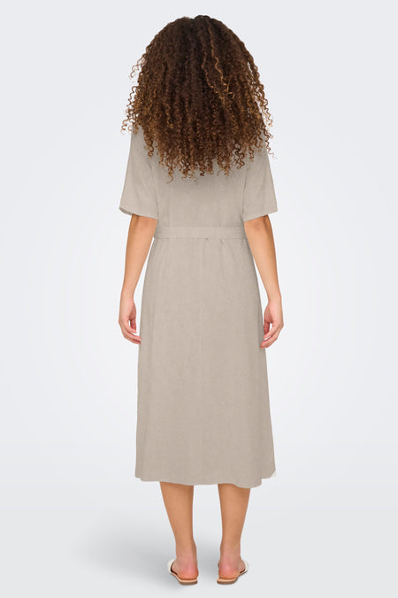 Beige kleedje met korte mouwen van JDY, gezien van achteren, met een ceintuur en krullend haar.

