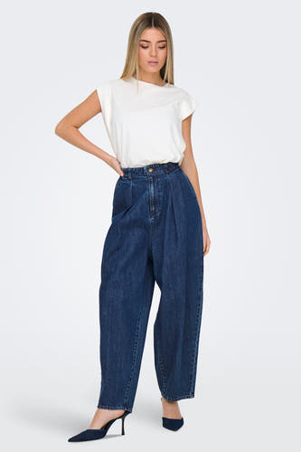 Donkerblauwe wijde jeans van ONLY, gedragen met een wit shirt en donkerblauwe pumps.