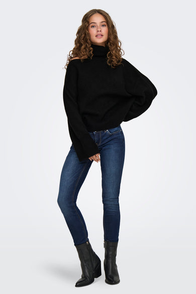 Zwarte rolkraagtrui van JDY, ruimvallend model met ribstructuur, gedragen met blauwe jeans en zwarte laarzen, front view.