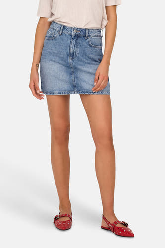 Korte lichtblauwe denim rok van ONLY, met een klassieke tailleband en rode platte schoenen.
