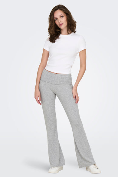 Grijze broek van ONLY met uitlopende pijpen, gecombineerd met een wit shirt en witte sneakers.