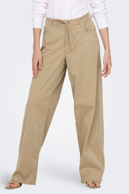 Pantalon beige de ONLY®, avec cordon de serrage à la taille et associé à une chemise blanche et des sandales.