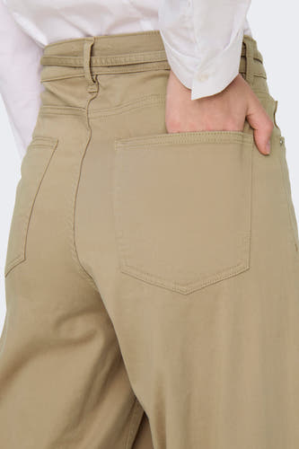 Beige broek van ONLY, met hand in de achterzak en zichtbare stiksels.