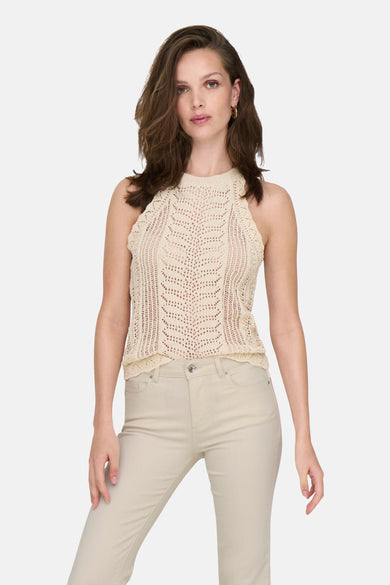 T-shirt écru sans manches ONLY, avec des détails ajourés et associé à un pantalon beige.