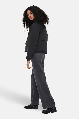 Manteau court noir de JDY, porté avec des jeans gris et des bottes noires.