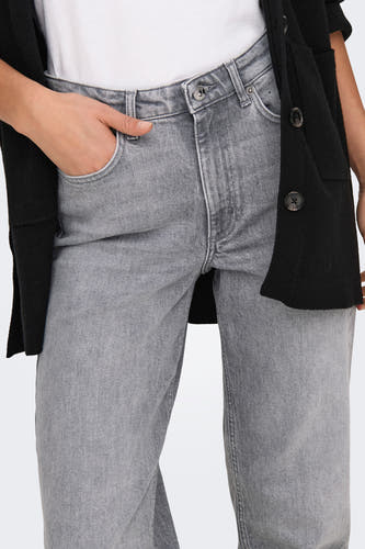 Grijze mom jeans van ONLY, met hand in de zak en een zwarte cardigan.
