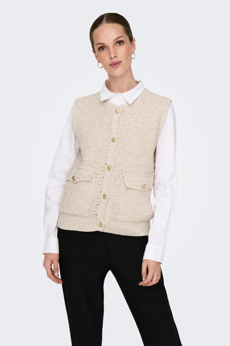 Gilet écru de ONLY, porté sur une chemise blanche et associé à des pantalons noirs et des baskets.