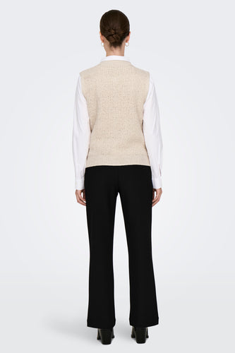 Ecrukleurig gilet van ONLY, rugaanzicht, gedragen over een wit overhemd met zwarte broek en hakken.
