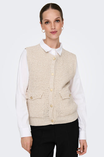 Ecrukleurig gilet van ONLY, met knopen en zakken, gedragen over een wit overhemd en zwarte broek.
