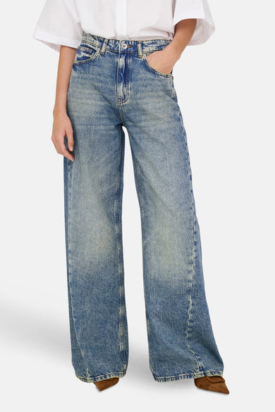 Wijde jeans in medium blauw denim van JDY, met subtiele wassingen en bruine schoenen.
