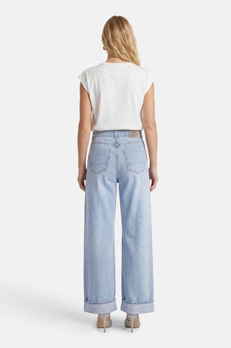 Lichtblauwe wide jeans van ONLY, met opgerolde zoom en gedragen met een wit T-shirt en glitterschoenen.
