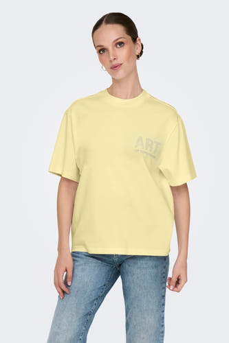 T-shirt jaune à manches courtes de ONLY, avec une inscription en strass, associé à un short blanc et des baskets.